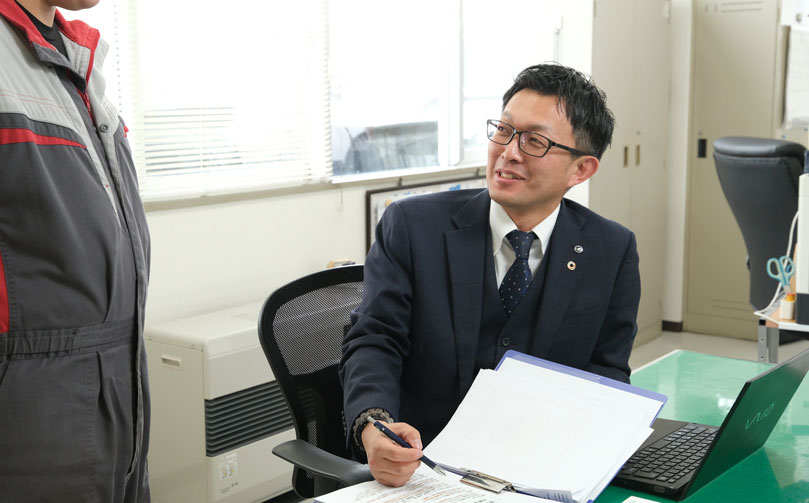部下と話をしている部品課の男性