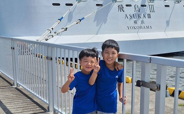 子ども2人が船の前で笑っている写真