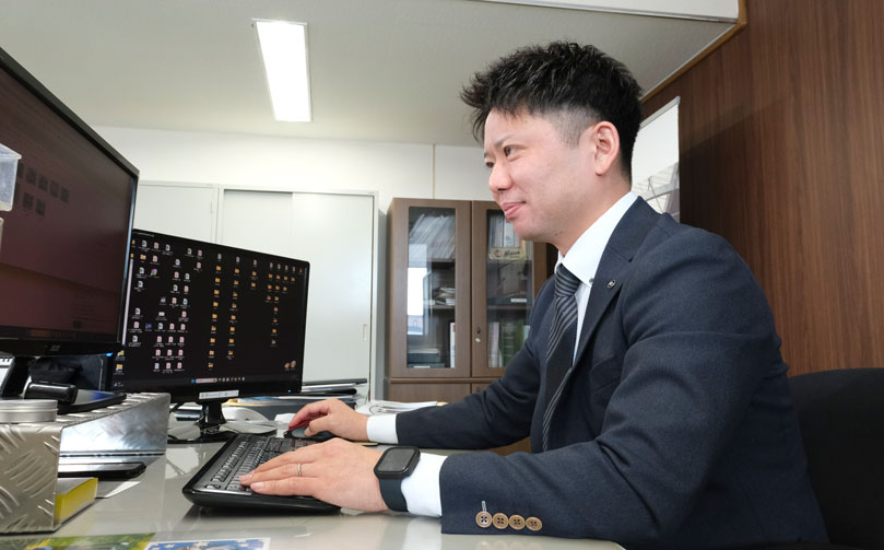 デスクワークをする販売課の男性