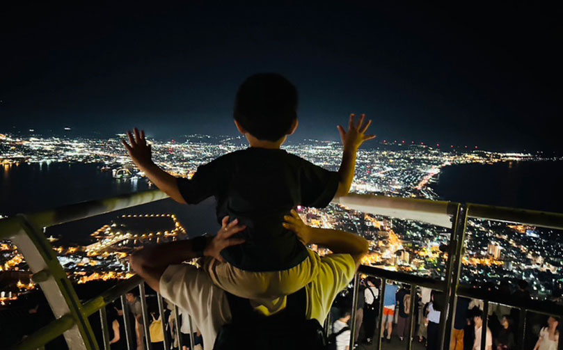 函館山から夜景を見る親子