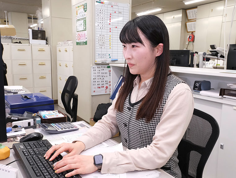 デスクで事務作業をする女性の写真