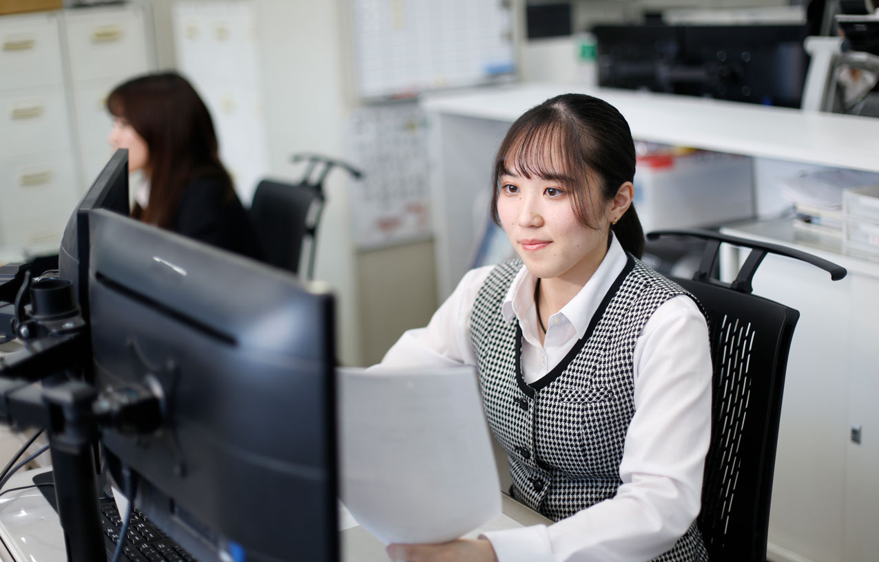 パソコン画面を見ながら文字を打ち込む事務の女性