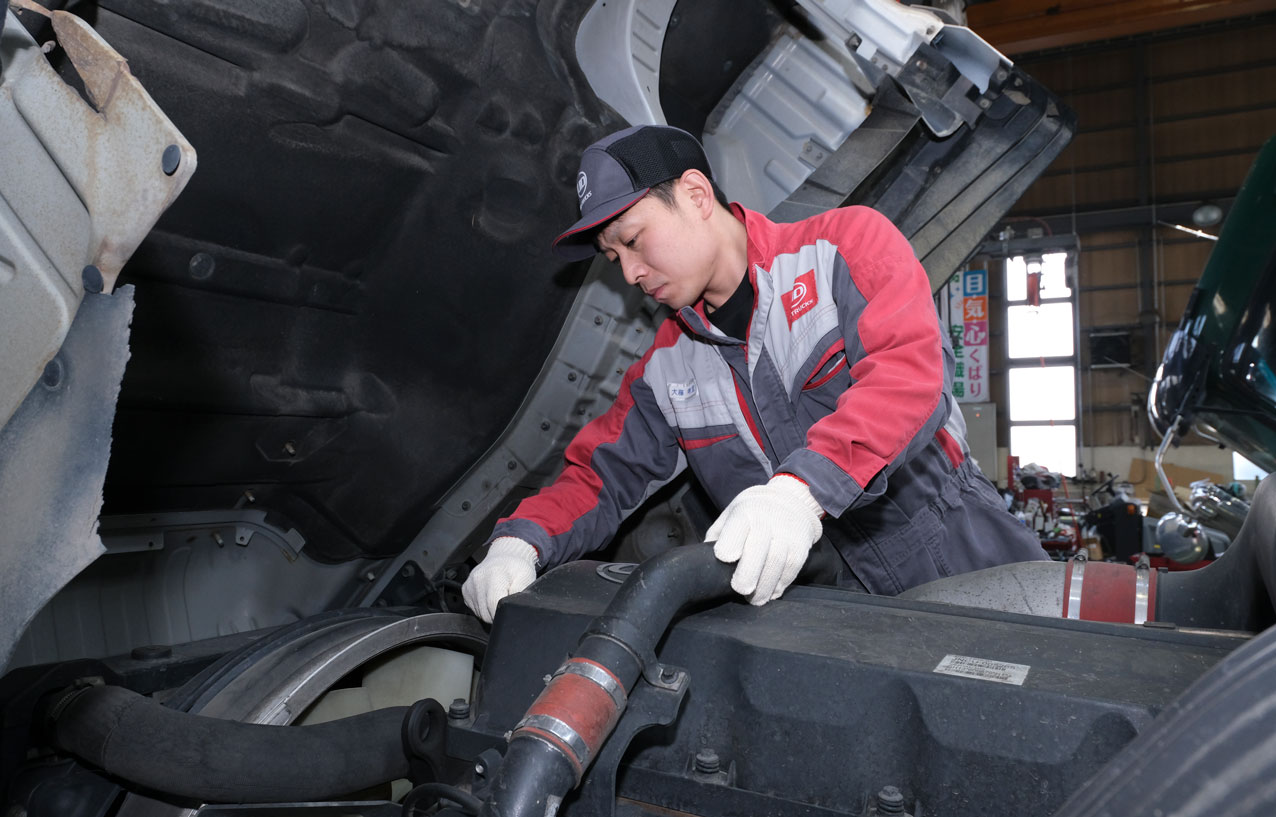 トラックの点検をしているメカニックの男性